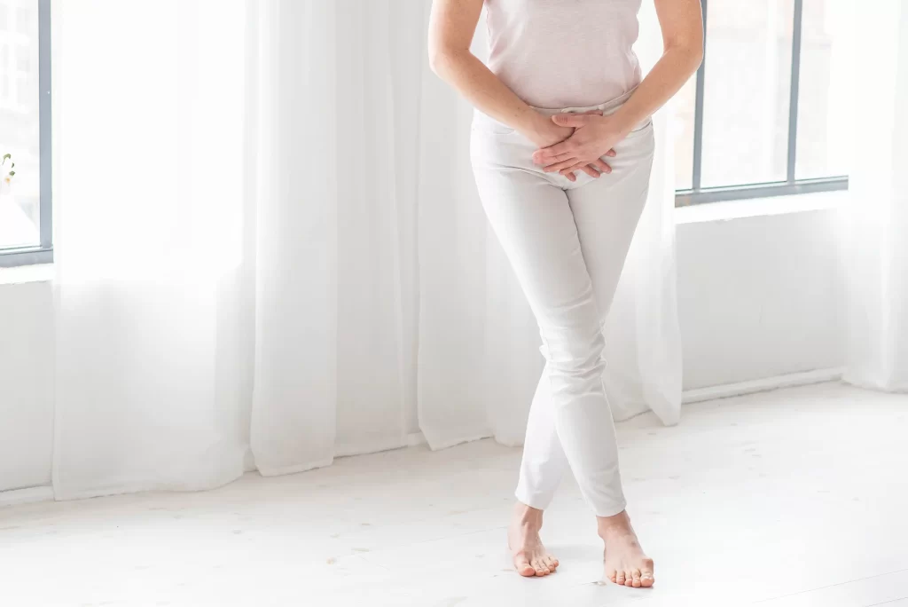 Nő álló testhelyzetben gátizomtorna illusztráció keresztbe tett lábbal, Fiziopro gyógytorna Dunaharaszti