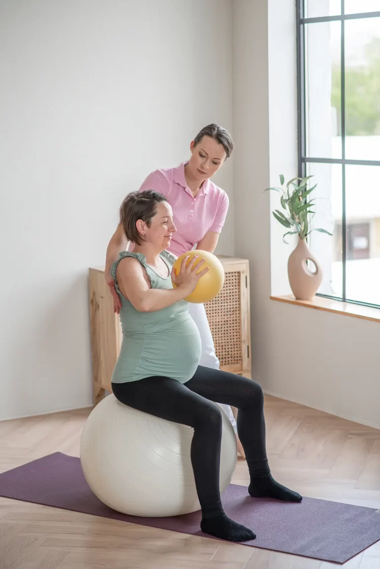 Iván Edina gyógytornász kismama tornát vezet várandós nővel fitball és labdagyakorlat közben, Dunaharaszti Fiziopro