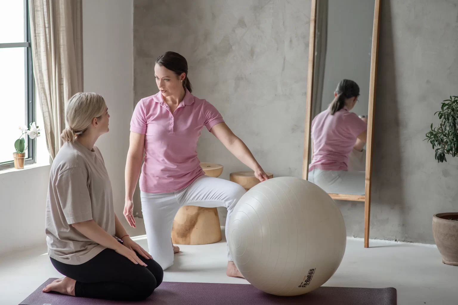 Iván Edina gyógytornász személyre szabott gyógytorna konzultációt tart pácienssel fitball mellett, Dunaharaszti Fiziopro